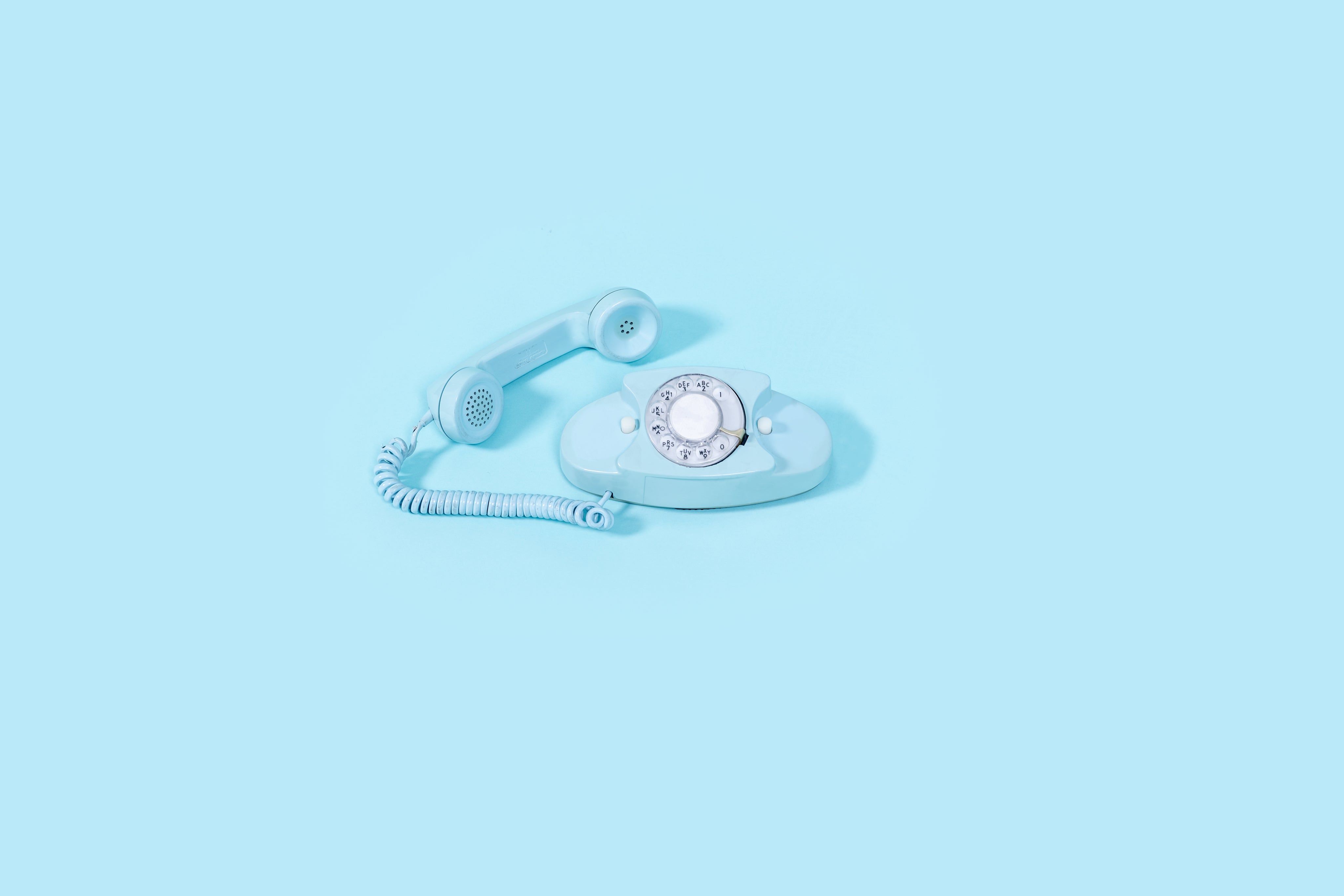 blue-vintage-rotary-phone-on-bright-blue-background.jpg